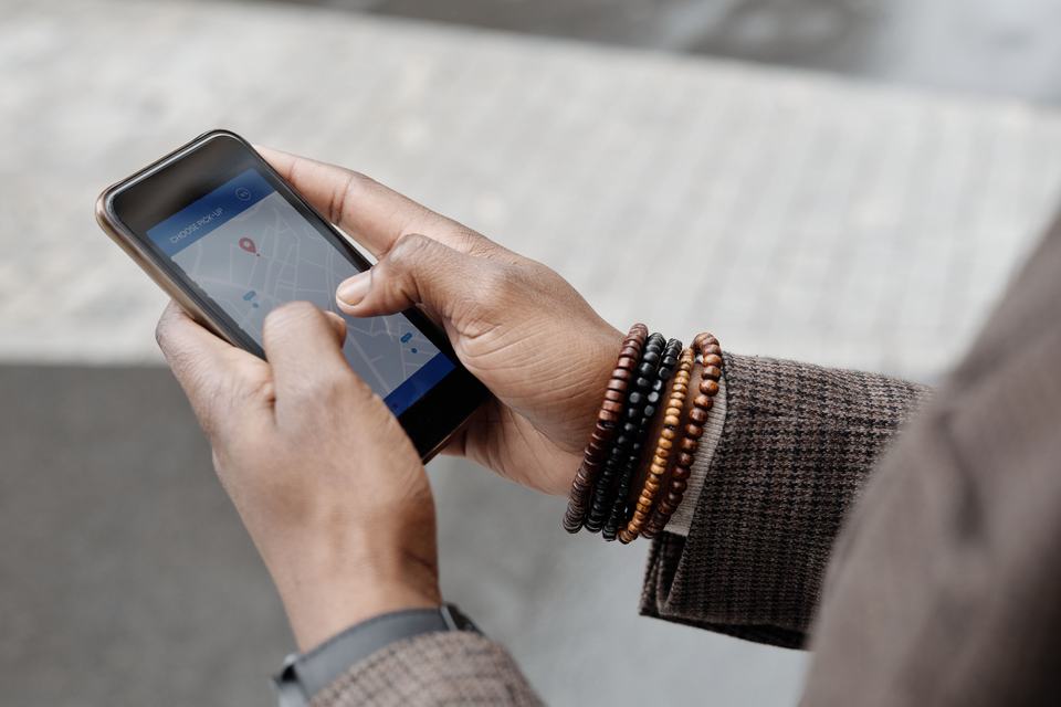 A hand checking a map app with location pins on a smartphone, standing in for verifying whether a competitor's listed address actually exists.