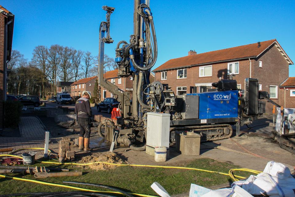 A worker operating equipment on a residential street outside your immediate office area, standing in for a real job in the outer part of a service area.
