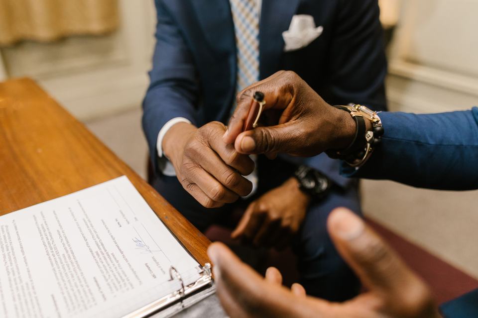 Two people signing a document, standing in for the client permission a real case study needs before a name or result is published.
