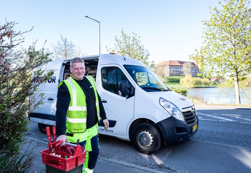 A real worker standing next to a company van with a tool case, standing in for the kind of team photo Google's own guidance recommends.