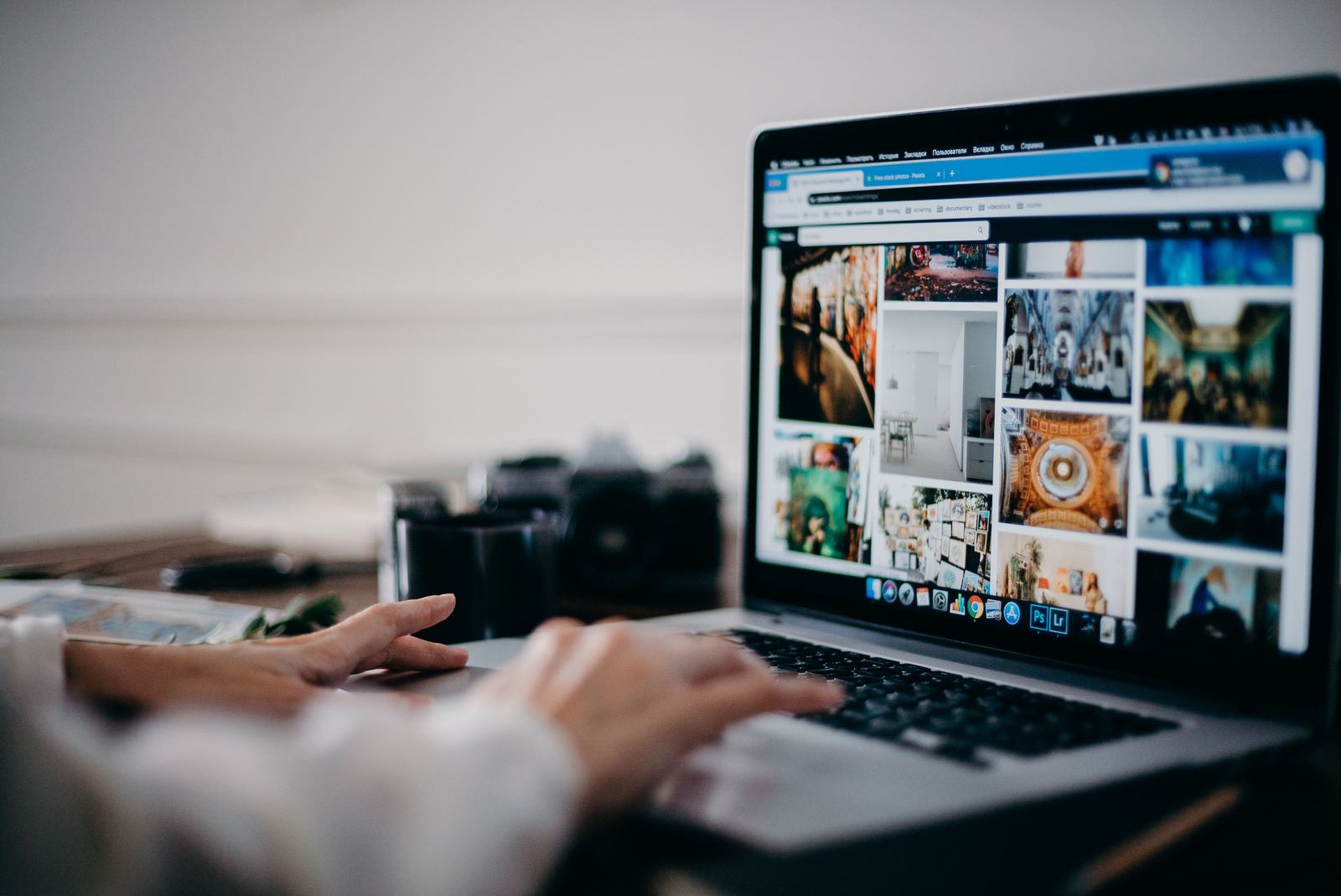 A person browsing a grid of photos on a laptop, standing in for reviewing and labeling job photos correctly before they go live.