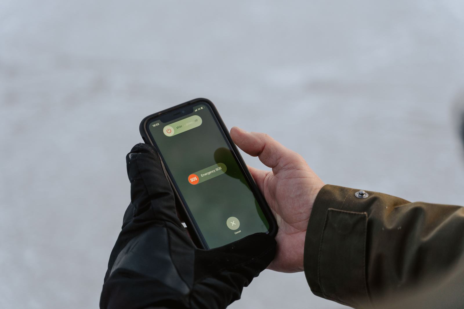 A hand holding a phone showing a warning alert, standing in for a business owner spotting a fake number on their own Google Maps listing.